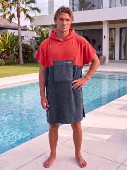 Poncho Waves ColorBlock Vermelho e Cinza vestido por modelo masculino, frente, junto a piscina