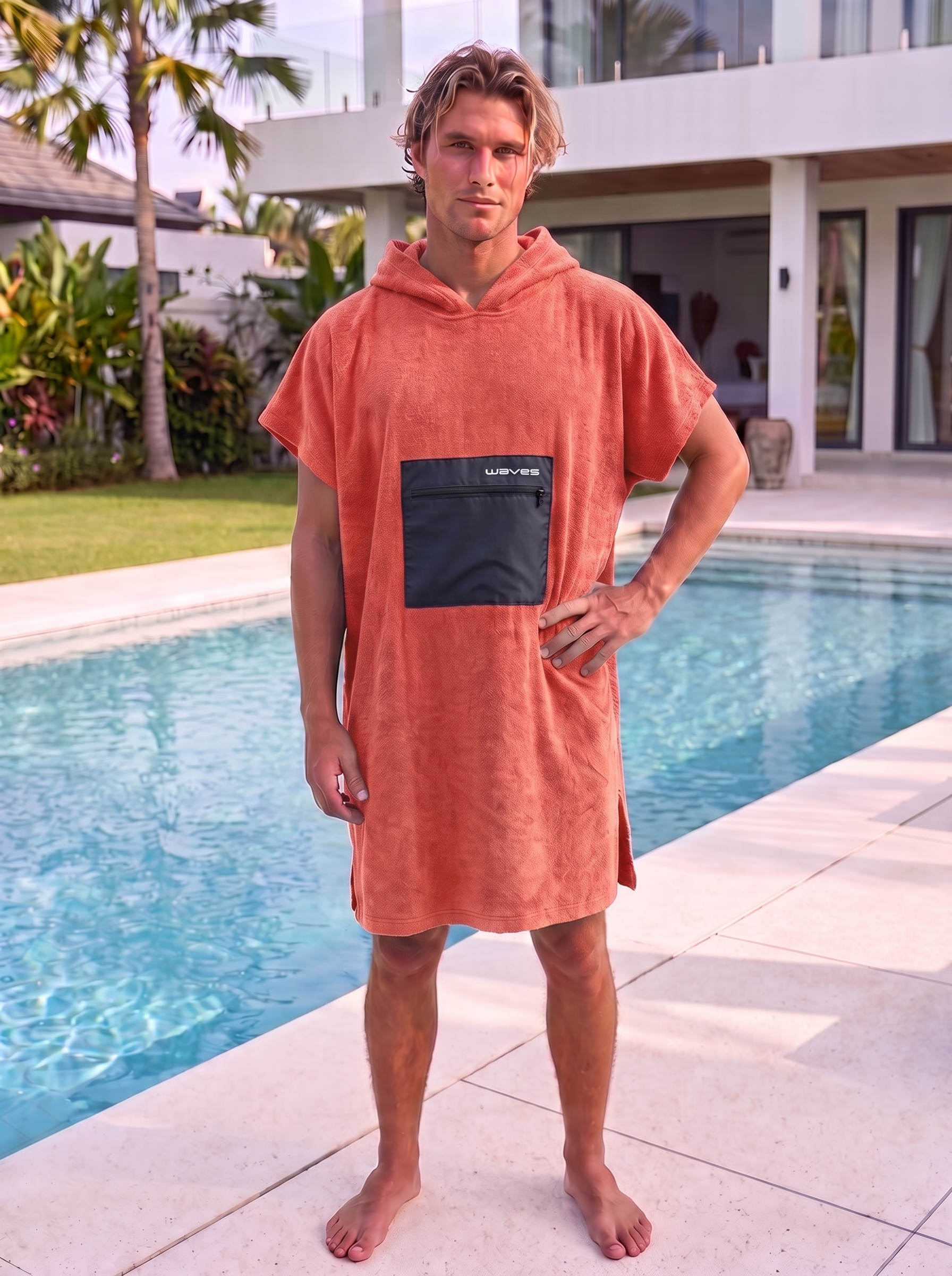 Poncho Waves Coral vestido por modelo masculino, frente, junto a piscina